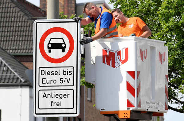 Những người công nhân lắp đặt biển báo giao thông cấm xe diesel tại Max-Brauer Allee ở trung tâm thành phố Hamburg, Đức vào ngày 16/5/2018. Ảnh: Fabian Bimmer