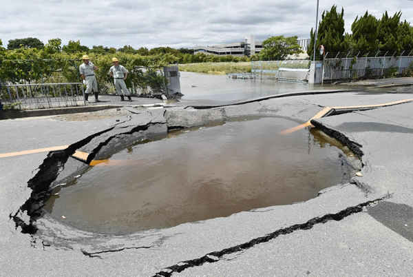 Một vết nứt lớn chứa đầy nước trên một con đường do đường ống nước bị vỡ sau trận động đất ở Takatsuki, tỉnh Osaka, phía Tây Nhật Bản vào ngày 18/6/2018