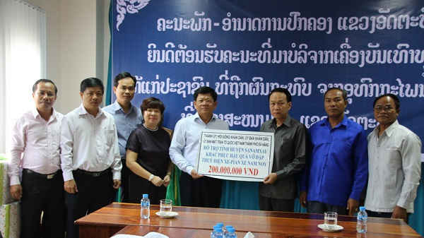 Phó Bí thư thường trực Thành ủy Đà Nẵng Võ Công Trí (thứ 5 từ trái sang) trao hỗ trợ cho huyện Sanamxay 200 triệu đồng