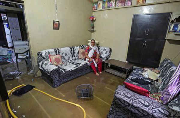 Một phụ nữ ngồi thất thần trong ngôi nhà bị ngập lụt của cô sau những trận mưa lớn ở Ahmedabad, Ấn Độ vào ngày 24/6/2018. Ảnh: Amit Dave