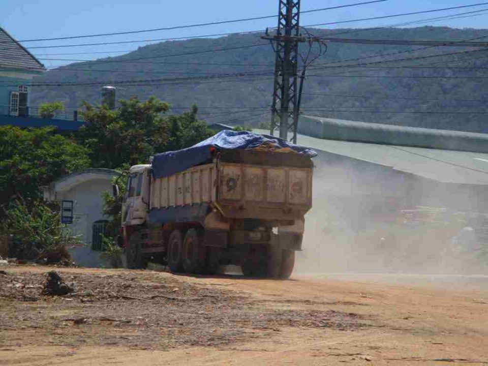 Xe tải chở đất từ mỏ đất ra đường Quốc lộ 1 tung bụi mù