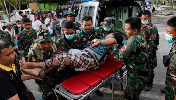 Binh lính Indonesia khiêng người phụ nữ bị thương sau khi đến bệnh viện Tanjung sau trận động đất xảy ra vào tối 5/8 ở phía Bắc Lombok, Indonesia vào ngày 7/8/2018. Ảnh: Beawiharta