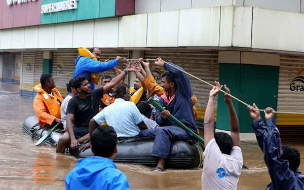 Nhân viên cứu hộ sơ tán người dân từ các khu vực bị ngập lụt sau khi xả lũ tại các đập Idamalayr, Cheruthoni và Mullaperiyar sau những trận mưa lớn ở ngoại ô thành phố Kochi, Ấn Độ vào ngày 16/8/2018. Ảnh: Sivaram V