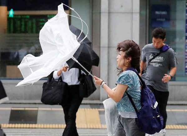 Người phụ nữ che ô nhưng bị gió mạnh và mưa lớn lật ngược ô trong cơn bão Jebi ở Tokyo, Nhật Bản vào ngày 4/9/2018