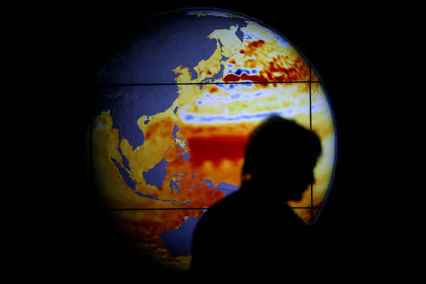 Một phụ nữ đi ngang qua bản đồ thể hiện độ cao của biển trong 22 năm qua trong Hội nghị Liên Hiệp Quốc về BĐKH 2015 (COP 21) được tổ chức ở Paris, Pháp vào ngày 11/12/2015. Ảnh: Stephane Mahe