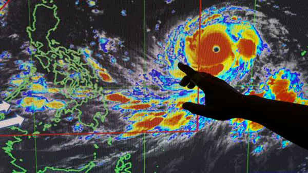 Một nhà dự báo minh họa hướng đi của bão Mangkhut khi nó tiếp cận Philippines