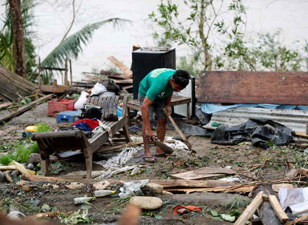 Một dân làng thu nhặt những gì còn lại của nhà ông ở Baggao. Ảnh: Francis R Malasig / EPA