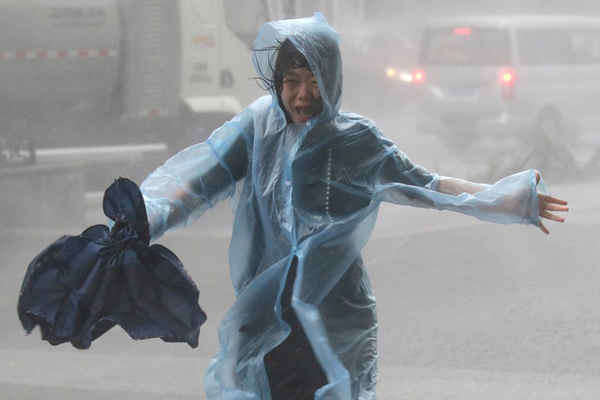 Một phụ nữ chạy trong mưa khi bão Mangkhut đổ bộ Thâm Quyến, Trung Quốc vào ngày 16/9/2018. Ảnh: Reuters / Jason Lee