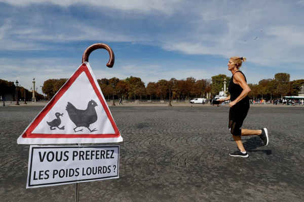 Một người chạy bộ và một biển báo có dòng chữ “Bạn có thích xe tải hạng nặng  không?”. Ảnh: Francois Guillot / AFP / Getty Images