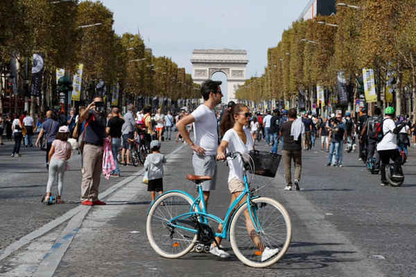 Người đi xe đạp và người đi bộ trước Arc de Triomphe. Ảnh: Francois Guillot / AFP / Getty Images