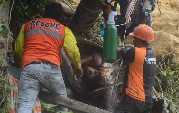 Lực lượng cứu hộ cứu một người sống sót từ đống đổ nát sau vụ lở đất ở Thành phố Naga, Cebu, Philippines vào ngày 20/9/2018. Ảnh: Reuters / Stringer