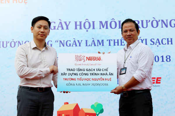 Đại diện Công ty Nestlé Việt Nam trao tượng trưng 10 000 viên gạch cho thầy Tống Thanh Quang, Hiệu trưởng trường tiểu học Nguyễn Huệ