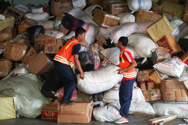 Các thành viên của lực lượng Không quân Indonesia xếp hàng hóa được viện trợ. Những hàng hóa này sẽ được vận chuyển đến các khu vực bị ảnh hưởng ở miền Trung Sulawesi, tại Sân bay quân sự Halim Perdanakusumah ở Jakarta, Indonesia. Ảnh: Bagus Indahono / EPA