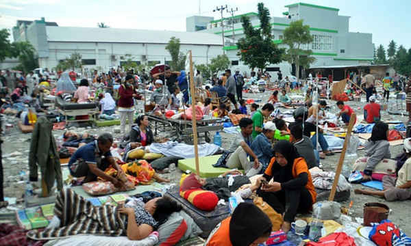 Nhân viên y tế điều trị và giúp đỡ bệnh nhân bên ngoài bệnh viện sau trận động đất và sóng thần tấn công Palu. Ảnh: Muhammad Rifki / AFP / Getty Images
