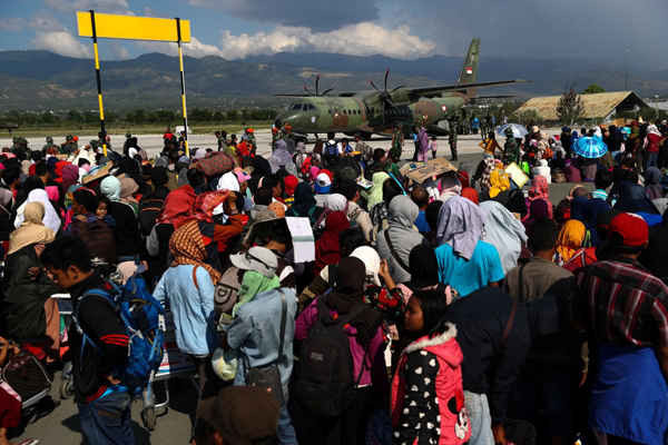 Người dân địa phương bị ảnh hưởng bởi trận động đất và sóng thần chờ đợi được lên máy bay quân sự tại Sân bay Mutiara Sis Al Jufri ở Palu, Trung Sulawesi, Indonesia vào, ngày 1/10/2018. Ảnh: Athit Perawongmetha