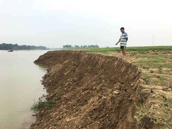 Ông Mai Văn Hòa ở thôn 7 xã Vĩnh Khang chỉ tay về diện tích đất sản xuất nông nghiệp của nhà ông bị sạt lở