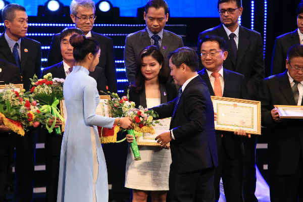 Bộ trưởng Bộ Kế hoạch và Đầu tư Nguyễn Chí Dũng trao bằng khen và hoa cho đại diện Nestlé Việt Nam