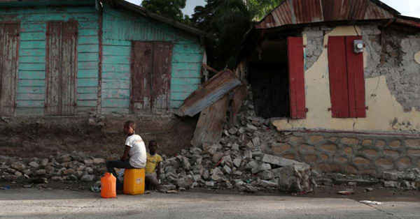 Trẻ em ngồi trước những ngôi nhà bị phá hủy trong một trận động đất tấn công miền Bắc Haiti cuối ngày 6/10 tại Gros Morne, Haiti vào ngày 8/10/2018. Ảnh: Ricardo Rojas