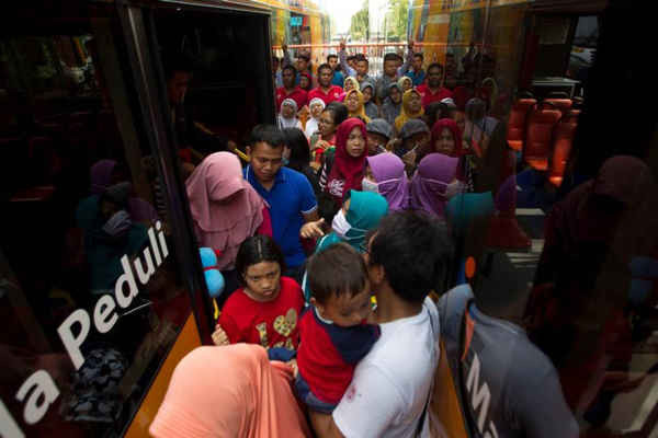 Cư dân chen lấn bên cạnh xe buýt Suroboyo sau khi đổi chai nhựa lấy vé tại ga Purbaya ở Surabaya, Indonesia vào ngày 21/10/2018. Ảnh: Sigit Pamungkas
