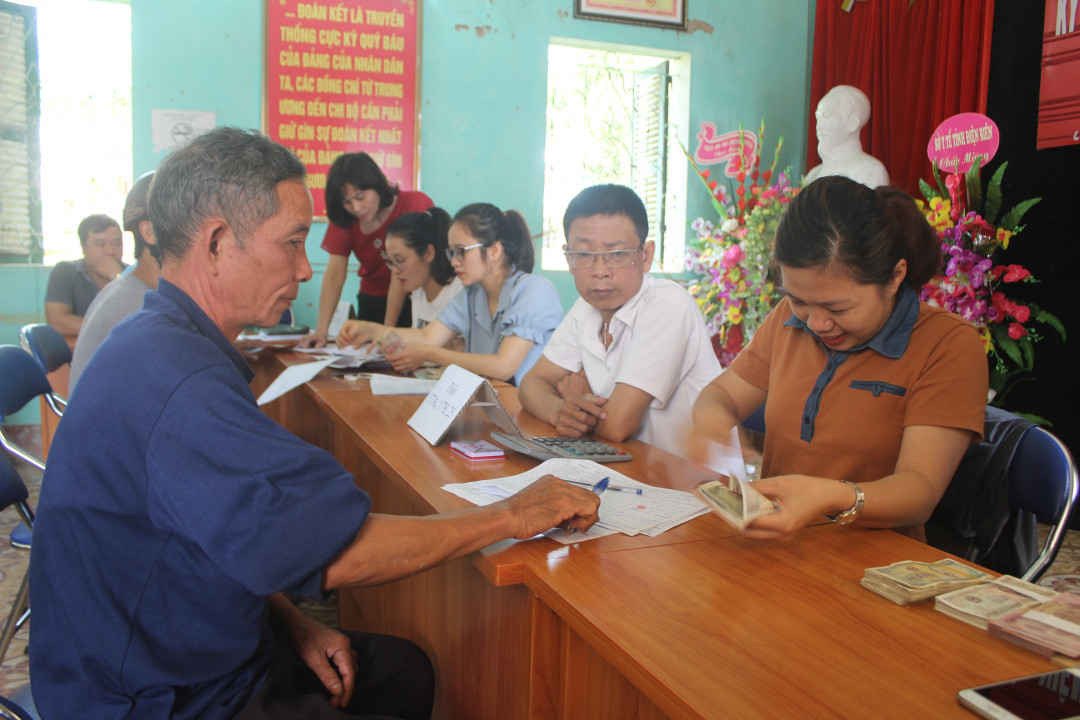 Người dân xã Thanh Nưa, huyện Điện Biên, tỉnh Điện Biên nhận tiền chi trả từ việc góp đất trồng cao su