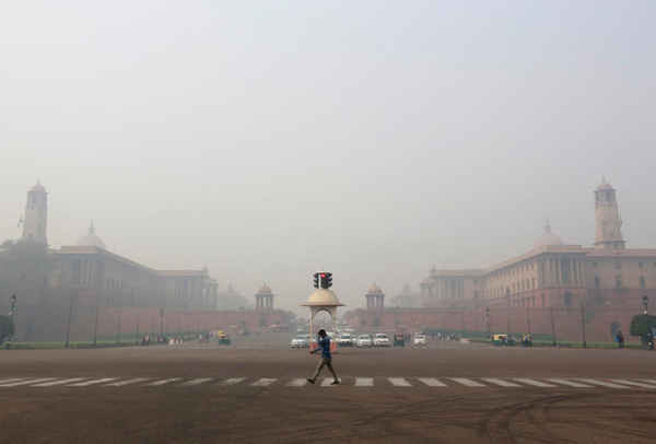 Một người đàn ông băng qua con đường bên cạnh các tòa nhà Bộ Quốc phòng và Bộ Nội vụ Ấn Độ vào một buổi sáng đầy sương mù ở New Delhi, Ấn Độ, ngày 5/11/2018. Ảnh: Reuters / Altaf Hussain