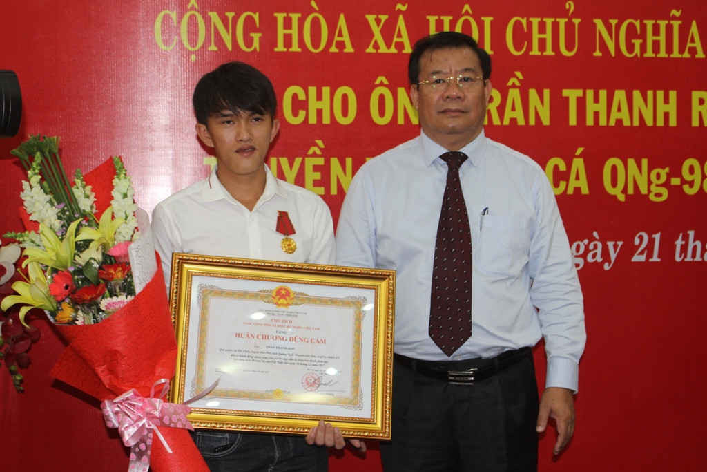 Ông Nguyễn Tăng Bính- Phó chủ tịch thường trực UBND tỉnh Quảng Ngãi trao huân chương dũng cảm cho ngư dân Trần Thanh Ron (Ảnh Nguyễn Ngọc)