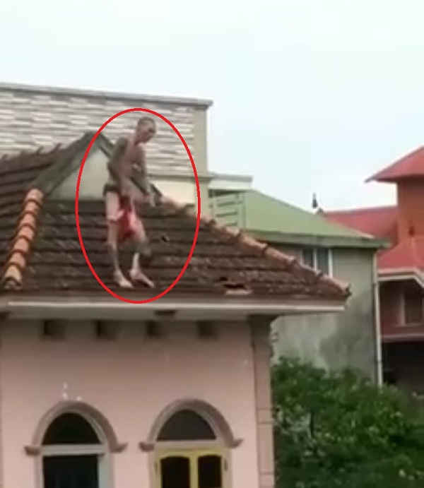 Đối tượng xách ngược đứa bé đứng nhảy nhót trên mái nhà cao tầng