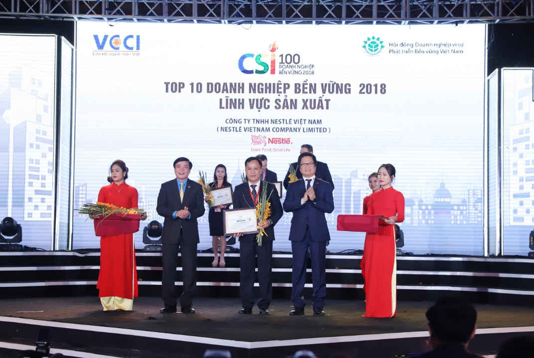 1  Ông Vũ Tiến Lộc, Chủ tịch VCCI, trao bằng khen và hoa cho đại diện Nestlé Việt Nam ông Nguyễn Ngọc Yên, Giám đốc phụ trách kinh doanh khu vực phía Bắc Nestlé Việt Nam