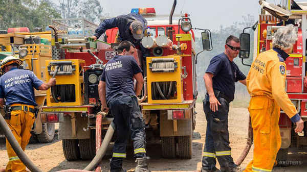 Các đội cứu hỏa thuộc bang New South Wales (NSW) của Australia đổ đầy xe tải chứa đầy nước cùng với các nhân viên cứu hỏa của bang Queensland cố gắng dập tắt đám cháy khi cháy rừng lan rộng trong một khu vực có tên gọi Captain Creek, nằm ở phía Bắc thị trấn Bundaberg ở Queensland, Australia vào ngày 2/12/2018. Ảnh: AAP / Paul Beutel
