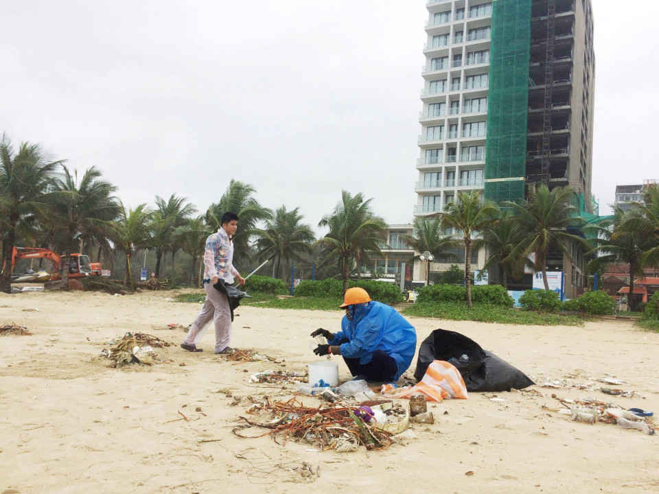 Công nhân công ty môi trường khẩn trương thu gom rác dọc bờ biển