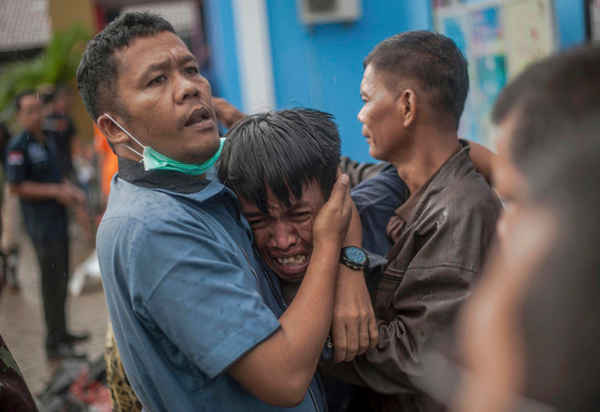 Một người đàn ông vô cùng đau xót khi nhận dạng thi thể người thân của anh trong số các thi thể nạn nhân sóng thần ở Carita, Indonesia vào ngày 23/12/2018. Ảnh: AP