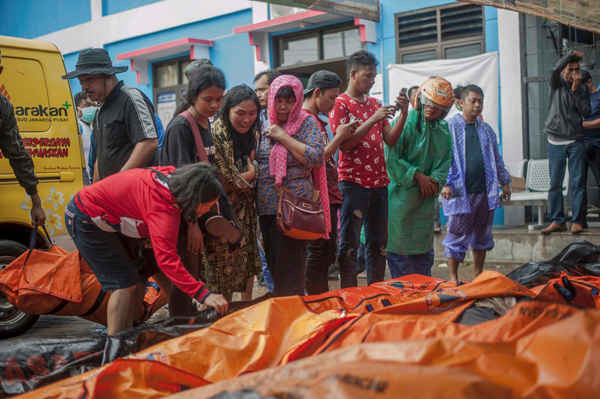 Mọi người tìm kiếm người thân trong số các thi thể của nạn nhân sóng thần. Ảnh: Fauzy Chaniago / AP