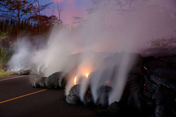 Khói núi lửa bốc lên từ dòng dung nham Kilauea băng qua đường Pohoiki qua quốc lộ 132 gần Pahoa, Hawaii. Ảnh: Marco Garcia / Reuters