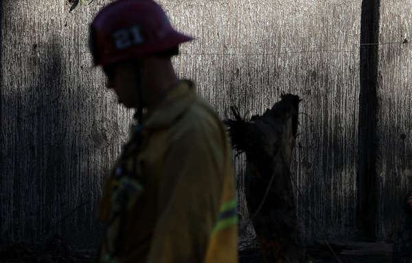 Người lính cứu hỏa đi bộ qua một bức tường phủ đầy bùn trước một ngôi nhà bị phá hủy bởi trận lở bùn ở Montecito, California vào ngày 11/1. 21 người chết và hàng trăm ngôi nhà bị phá hủy hoặc hư hỏng. Ảnh: Justin Sullivan / Getty Images