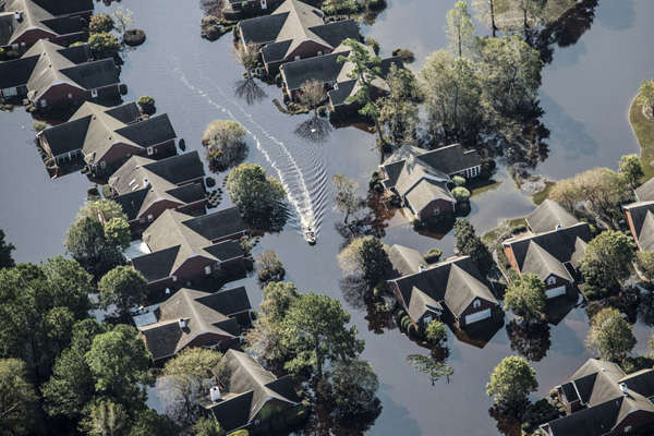 Một chiếc thuyền đi qua một khu phố bị ngập lụt ở Wallace, Bắc Carolina vào ngày 21 tháng 9. Những trận lũ lụt lớn trong lịch sử càn quét phần lớn miền Đông Bắc Carolina sau cơn bão Florence. Ảnh: Alex Classicalblewski / Bloomberg qua Getty Images