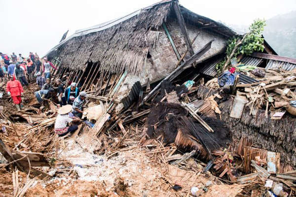Nhân viên cứu hộ tìm kiếm các nạn nhân gần một ngôi nhà bị sập sau vụ lở đất tại huyện Cisolok ở Sukabumi, tỉnh Tây Java, Indonesia vào ngày 1/1/2019. Ảnh: Antara Foto / M Agung Rajasa