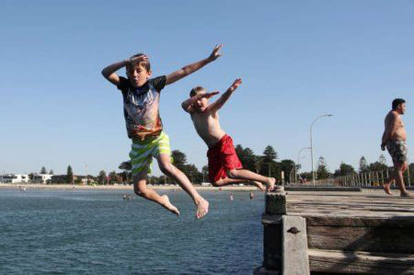 Trẻ em nhảy xuống nước khỏi bến tàu Altona ở Melbourne, Úc vào ngày 4/1/2019. Ảnh: AAP / David Crosling