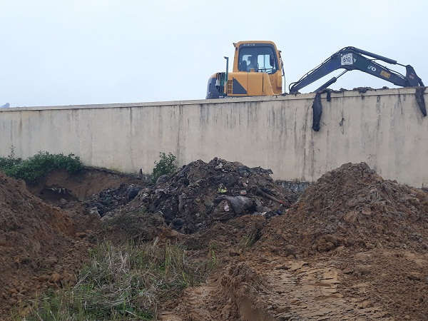Do bãi rác quá tải, đơn vị thu gom đào hố phía ngoài tường rào rồi chôn lấp thô sơ