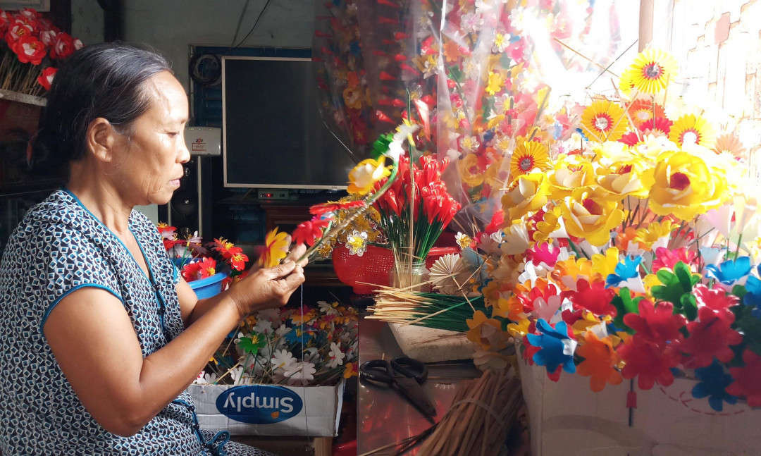 “Các công đoạn làm hoa giấy nghe có vẻ đơn giản làm cho được đẹp thì hơi khó. Người nào làm hoa giấy thành thạo thì một ngày làm được khoảng 20 bông hoa, còn không thì một nữa thôi...”, bà Phan Thị Thanh (ảnh, 59 tuổi) chia sẻ