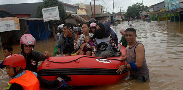 Nhân viên cứu hộ đẩy một chiếc thuyền bơm hơi khi họ sơ tán người dân sau lũ lụt ở Makassar, Nam Sulawesi, Indonesia vào ngày 23/1/2019. Ảnh: Abriawan Abhe