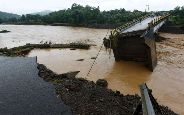Người dân địa phương nhìn cây cầu bị phá hủy sau khi lũ lụt tấn công Manuju ở Gowa, Nam Sulawesi, Indonesia vào ngày 23/1/2019. Ảnh: Antara Foto / Yusran Uccang