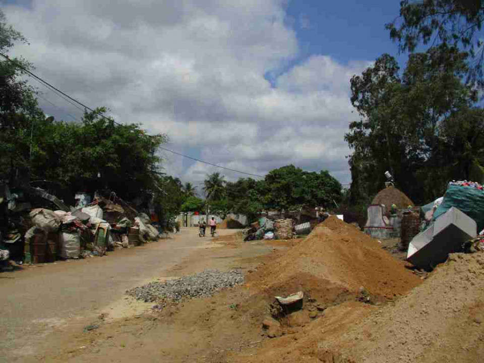 Phế liệu chất đống cùng với cát, đất nằm ngổn ngang hai bên đường làm ảnh hưởng đường đi chung tại thôn Xuân An, xã Cát Minh