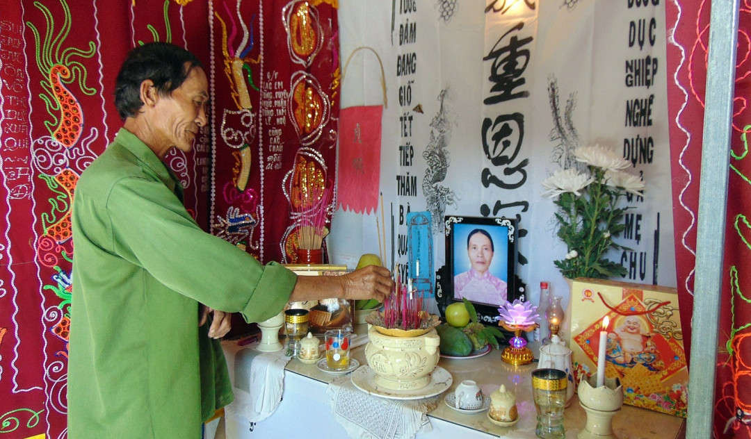 Ông Lê Triều (65 tuổi, trú đội 6B, thôn Hòa Bình, xã Duy Phước) thắp nén nhang tưởng nhớ người vợ vừa qua đời vì mắc bệnh ung thư đại tràng