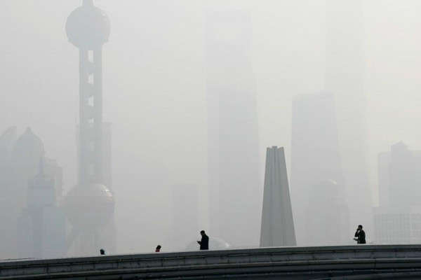 Mọi người đi bộ trên một cây cầu trước khu tài chính Pudong, nơi phủ đầy sương khói trong một ngày ô nhiễm ở Thượng Hải, Trung Quốc vào ngày 2/11/2018. Ảnh: Aly Song