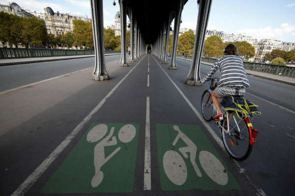 Một người phụ nữ đạp xe trên làn đường dành cho xe đạp trên cầu Pont de Bir-Hakeim ở Paris, Pháp vào ngày 14/9/2018. Ảnh: Gonzalo Fuentes