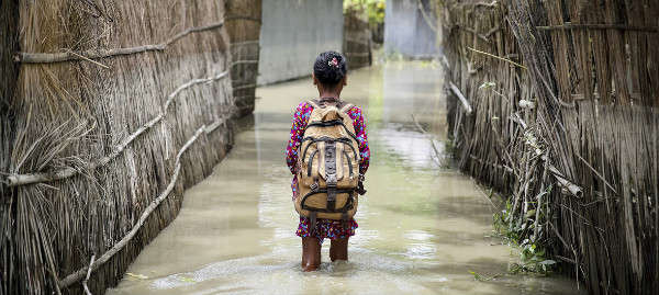 Một bé gái lội qua nước trên đường đến trường ở quận Kurigram, phía Bắc Bangladesh trong trận lụt hồi tháng 8/2016