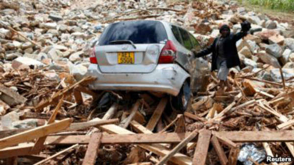 Một người đàn ông đứng bên cạnh chiếc xe của anh ta sau khi chiếc xe này bị cuốn vào những mảnh vụn do bão Idai để lại ở Chimanimani, Zimbabwe vào ngày 23/3/2019. Ảnh: Philimon Bulawayo