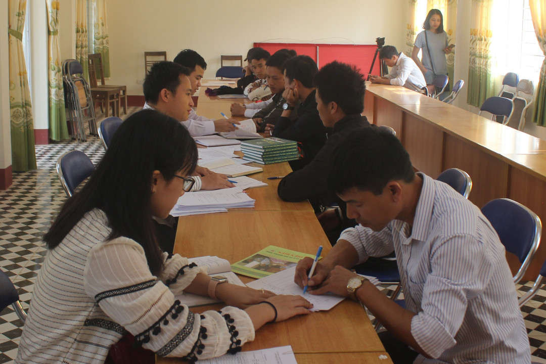 Cán bộ Quỹ bảo vệ và Phát triển rừng tỉnh Điện Biên hướng dẫn người dân ký cam kết mở và nhận tiền chi trả DVMTR qua tài khoản ngân hàng