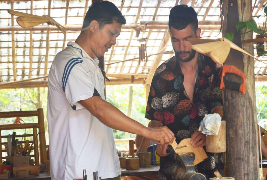 Anh Võ Tấn Tân, chủ xưởng tre Taboo Bamboo hướng dẫn du khách làm sản phẩm lưu niệm từ tre