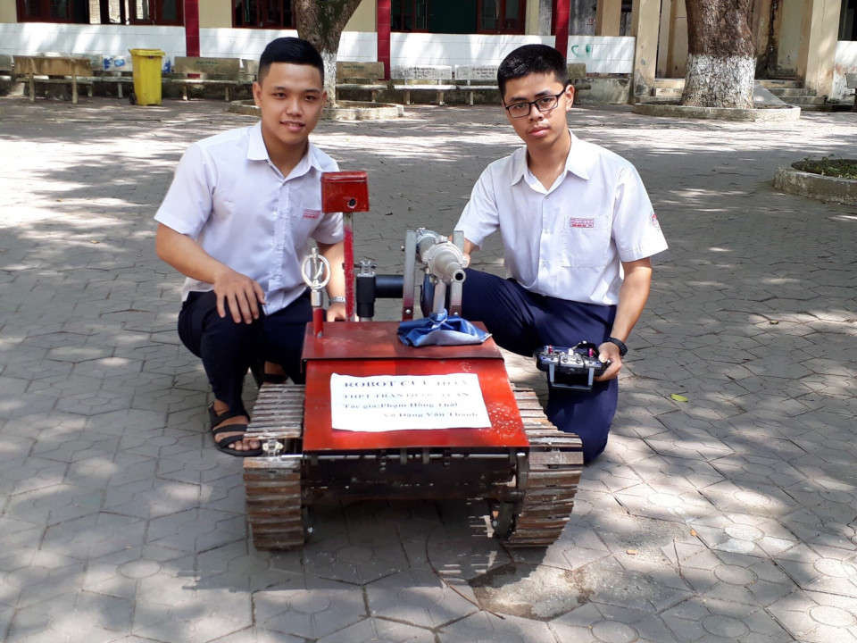 Hai em Phạm Hồng Thái (bên phải) và Võ Đặng Văn Thành (bên trái) cùng với sản phẩm Robot cứu hỏa của mình